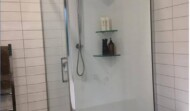 Full acrylic shower with tiled walls.