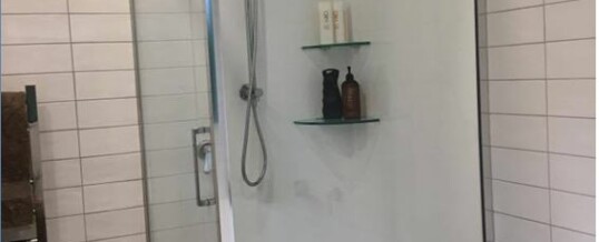 Full acrylic shower with tiled walls.