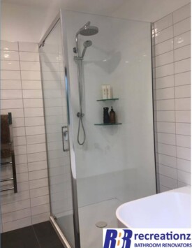 Full acrylic shower with tiled walls.